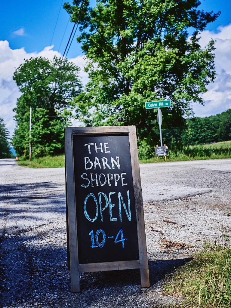 chalk sidewalk sign reads "The Barn Shoppe OPEN 10 - 4"